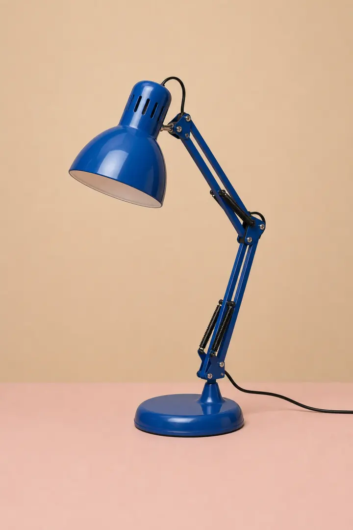 Cobalt-blue desk lamp in a warm studio scene before background removal.